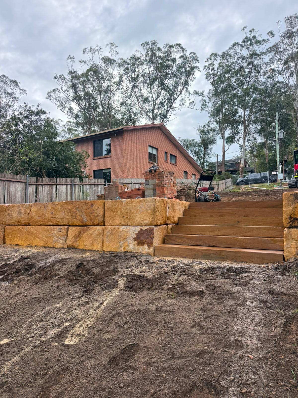 Sandstone retaining wall with matching steps built on a residential site